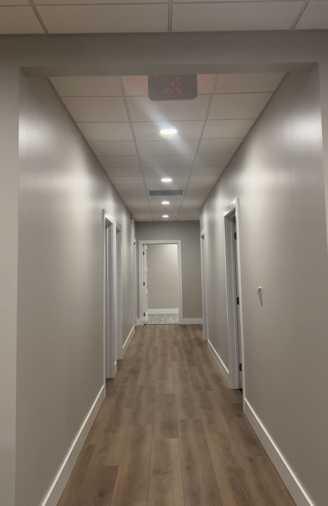 a long hallway with white walls and wooden floors