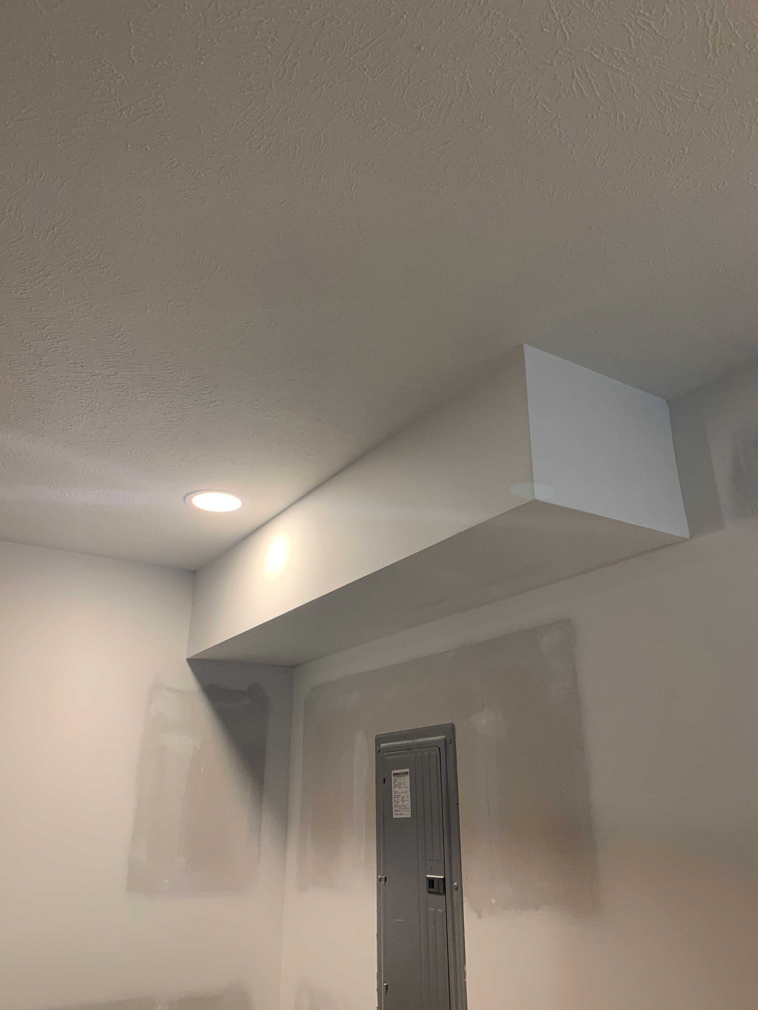 a white room with a metal door and a white wall