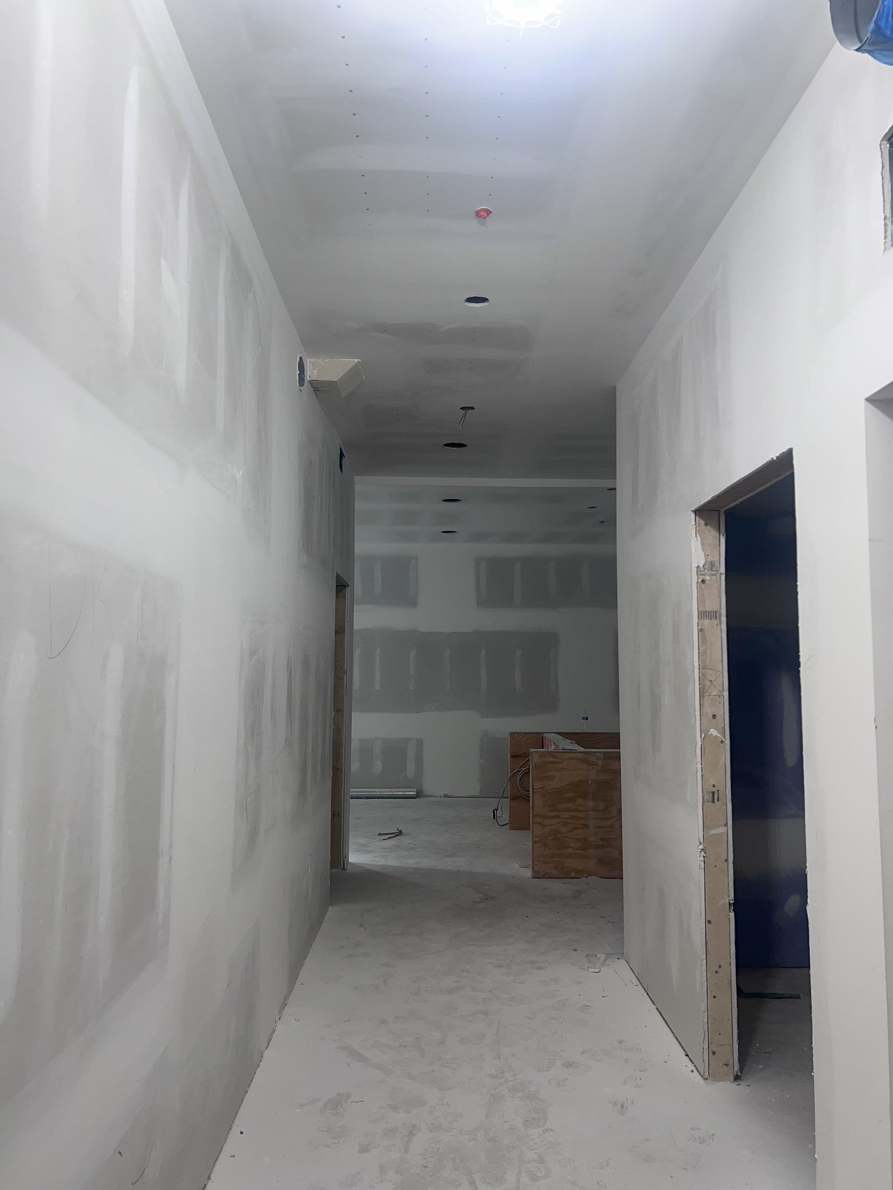 an empty room with white walls and a blue door