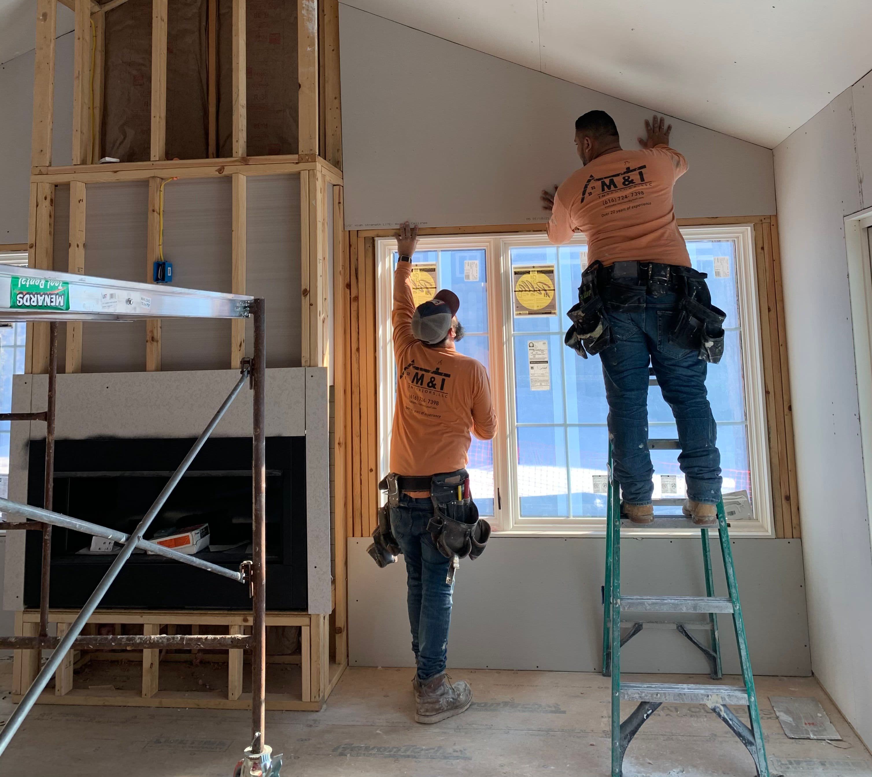 a couple of men standing on top of a ladder