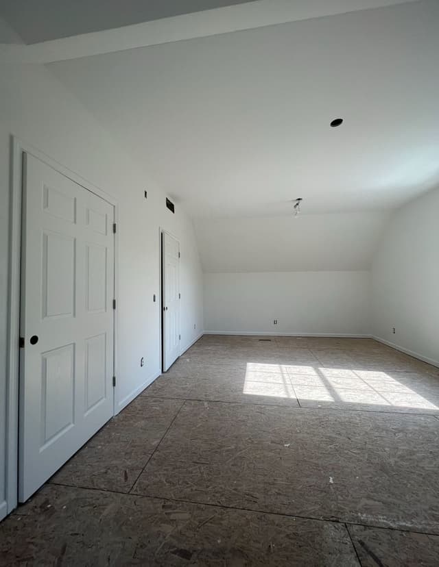 an empty room with three doors and a window