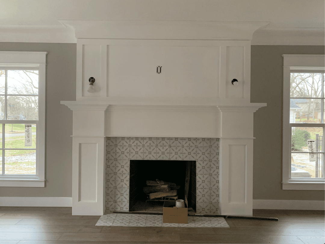 a living room with a fireplace and two windows