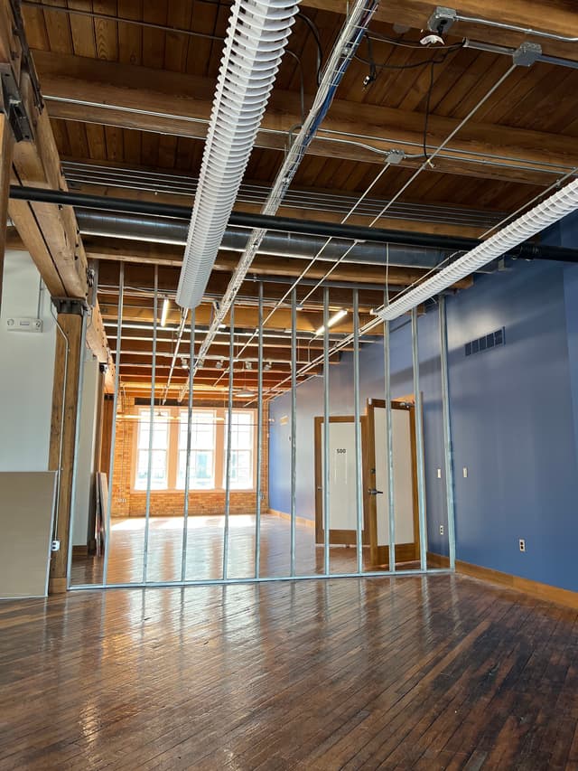 an empty room with a ceiling fan and a hard wood floor
