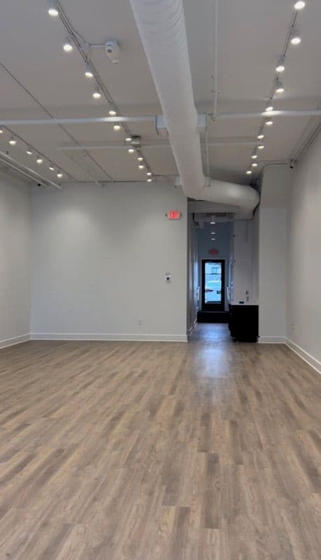 an empty room with hard wood floors and white walls